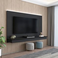 a flat screen tv mounted on the wall in a living room next to a potted plant