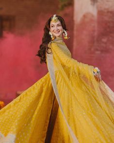 a woman in a yellow dress posing for the camera