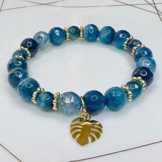 Round Faceted Blue/Turquiose Crackle Agate bracelet with Gold Leaf Charm. Gemstone sizes 10mm and 8mm. Handmade with durable stretch elastic string.  Size 8 inches, approximate. It is believed that the Blue Agate stone helps harmonize your energy. It assists in reducing negative energies, helping you stay relaxed and peaceful. Tranquility & Peace. CARE INSTRUCTIONS:  Take it off before bathing, exercising, swimming. Keep your bracelet in a dry place.  Don't wear it in a wet environment such as a Unique Blue Cheap Bracelets, Cheap Handmade Round Bracelets, Cheap Blue Bracelets For Vacation, Cheap Blue Bracelet For Vacation, Affordable Blue Bracelets With Faceted Beads, Affordable Blue Beaded Round Bracelets, Affordable Blue Faceted Beads Bracelet, Cheap Blue Crystal Round Bracelet, Affordable Round Blue Crystal Bracelet