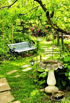 a bench sitting in the middle of a lush green park