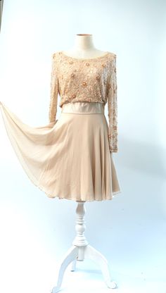 "Coolest dress...could be a wedding dress...or a guest of.. In a peach ivory with beautiful silkabsolutely stunning!! Excellent Beaded on tulle lined in silk Measuring: 36\" length Bust: 36\" Waist: 26\" Hip: 36\" + Sleeves: 22\" Pet Free/smoke free Enjoy!" Elegant Flowy Mother Of The Bride Dress For Party, Elegant Cream Dress With Sheer Bodice, Cream Dress With Sheer Bodice For Evening, Glamorous Beige Wedding Evening Dress, Beige Evening Dress For Wedding Guest, Elegant Apricot Chiffon Dress, Fitted Beige Evening Dress For Wedding Guest, Fitted Peach Dress For Wedding, Elegant Sheer Mother Of The Bride Party Dress