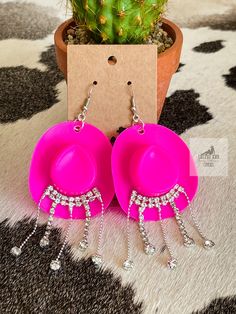 Saddle up in style with our Pink Cowgirl Rhinestone Statement Earrings from Cactus and Coral Country Boutique! These dazzling beauties are a perfect blend of Western flair and feminine charm, adding a touch of rodeo royalty to any outfit. Crafted to make you shine in the spotlight, they're the ultimate cowgirl accessory. Ride into fashion with us and explore our Western-inspired jewelry collection! Rhinestone Cowgirl Bachelorette, Western Cuff Bracelet, Rhinestone Cowboy Hat, Cowgirl Rhinestone, Cowboy Hat Earrings, Mini Cowboy Hat, Mini Cowboy, Pink Cowgirl Hat, Cowgirl Bachelorette Parties