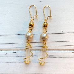 "Intriguing 3 tiered boho earrings with tiny white crystals wired wrapped and sophisticated faux pearls. Earrings have a 2.75\" drop with gold plated, nickel free ear wires. These lightweight beauties will be the perfect finishing touch to complete your boho look!" Adjustable Gold Metal Pearl Earrings, Gold Pearl Adjustable Earrings, Gold Wire-wrapped Crystal Earrings, Gold Wire-wrapped Pearl Earrings, Gold Wire Wrapped Pearl Earrings, Gold Wire Wrapped Crystal Earrings, Gold Wire Wrapped Crystal Earrings In Brass, Bohemian Gold Beaded Pearl Earrings, Adjustable Gold Pearl Earrings With Ear Wire