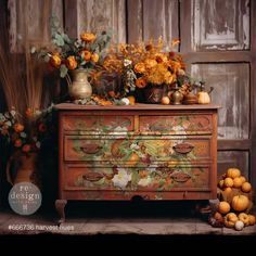 an old dresser with flowers and pumpkins on it