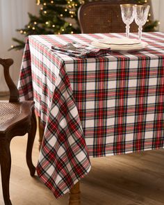 a table with a plaid cloth on it and two wine glasses in front of the table