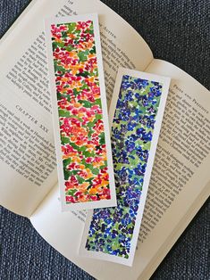 two bookmarks sitting on top of an open book