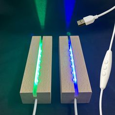 two pieces of wood with different colored lights on them next to a charger plugged in