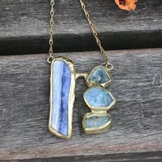 Inspired from the hues, texture and movement of a waterfall, blue kyanite and aquamarine are embedded in brass anchored on our signature brass cuff with a handmade clasp. Pendant Length 1 1/2" Width 1 1/2" Chain Length 16" - 18" This piece is handmade-to-order, please allow 1 - 2 weeks to ship unless this piece is in stock. Each piece will vary slightly due to the uniqueness of the stones. All metal is nickel free. Blue Brass Pendant Jewelry, Blue Brass Jewelry For Jewelry Making, Hand-forged Blue Jewelry Gift, Blue Hand Forged Pendant Necklace, Hand Forged Blue Pendant Necklace, Unique Blue Brass Jewelry, Unique Blue Necklace With Patina, Hand-forged Blue Pendant Necklace, Spiritual Blue Brass Jewelry