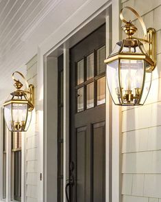 two lights on the side of a house next to a front door and entryway