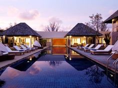 an outdoor swimming pool surrounded by lounge chairs