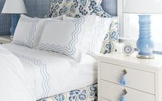 a bedroom with blue and white decor on the headboard, nightstands and lamps