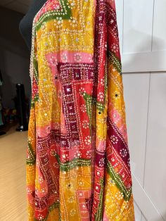 Experience the beauty of traditional Phulkari style with our Multicolor Dupatta. Made with a soft and luxurious silk finish, this dupatta features real mirror accents and stunning designs. Its heavy-weight construction makes it perfect for special occasions like Navaratri. Elevate your wardrobe with this must-have accessory. Approx 2.5 meters length Multicolor Art Silk Anarkali Set With Traditional Drape, Multicolor Anarkali Set With Mirror Work For Festive Season, Bandhani Print Saree For Festival, Bollywood Style Multicolor Chanderi Lehenga, Traditional Multicolor Art Silk Choli, Bollywood Style Multicolor Choli With Dupatta, Festive Multicolor Sharara With Mirror Work, Multicolor Semi-stitched Anarkali Set With Gota Work, Semi-stitched Multicolor Anarkali Set With Gota Work