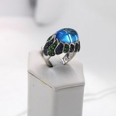 "Beautiful 12 carat blue topaz and tsavorite garnets and blue sapphires in a unique vintage 14K white gold ring.  Marked \"14K\".  A wonderful addition to your personal jewelry collection. FREE SHIPPING! Details:  14K Yellow Gold: (as shown in picture) Natural Topaz:  (1) 16 mm x 12 mm cabochon Approximate Gem Weight: 12.0 carats Gem Color: Blue Natural Tsavorite Garnet: (51) 1.25 mm round  Approximate Gem Weight: 1.53 carats Gem Color: Green Natural Blue Sapphire: (55) 1.25 mm round Approximate Gem Weight: 1.65 carats Gem Color: Deep Blue Ring Size: 7 Total Weight: 13.8 grams FREE domestic shipping by USPS Priority Mail Delivery Confirmation and includes insurance. If the item is to be shipped internationally Etsy will calculate postage. Please notify us at purchase if you are buying more Oval Blue Multi-stone Emerald Ring, Luxury Blue Cabochon Gemstones, Elegant Blue Multi-stone Emerald Ring, Blue Multi-stone Opal Ring In Fine Jewelry Style, Blue Multi-stone Opal Ring Fine Jewelry, Luxury Blue Opal Ring With Gemstone, Luxury Blue Opal Gemstone Ring, Fine Blue Opal Multi-stone Ring, Blue Multi-stone Jewelry With Oval Cabochon