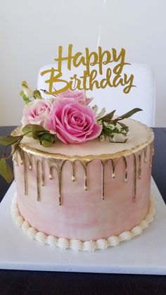 a birthday cake with pink frosting and flowers on top