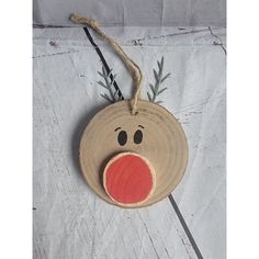 a wooden ornament with a red nose and antlers hanging on a string