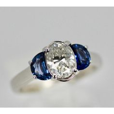 three stone ring with blue and white stones on the sides, set in 18k white gold