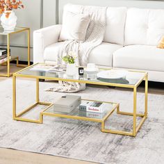 a living room with white couches and gold coffee table