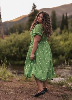 Escape To The Woods This vibrant green dress adorned with a delicate white floral print captures the essence of a sunlit meadow. The dress features a smocked back with a charming button-down front and short puff sleeves for a classic touch. Inspired by nature's beauty, this dress is the perfect choice for a leisurely stroll or special occasion. Functional front buttons Smocked back Elastic sleeves Pockets Recommend sizing up for larger busts Model Details Content + Care 100% Cotton Machine Wash Summer Garden Party Dress With Ditsy Floral Print, Summer Garden Party Smocked Dress With Ditsy Floral Print, Green Puff Sleeve Dress In Cottagecore Style, Spring Smocked Dress With Short Gathered Sleeves, Summer Floral Print Smocked Dress With Puff Sleeves, Summer Smocked Floral Print Dress With Puff Sleeves, Green Puff Sleeve Dress With Smocked Bodice, Puff Sleeve Smocked Dress With Floral Print For Summer, Summer Smocked Dress With Puff Sleeves And Floral Print