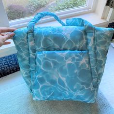 New With Tag. First Two Pictures Taken By Me. Color: Pool A Mini Cloud Bag That Actually Feels Like A Cloud. Soft, Puffy Exterior Keeps Your Essentials Cozy. Exterior Pocket. Machine Washable. 100% Recycled Ripstop Nylon, Recycled Pet Polyfill 10"H 15.75"W (At Opening, 10" At Base) 5.5"D 11" Strap Drop ** First Time On Poshmark? Use Code Emmmamercer When You Create Your Poshmark Account To Receive A $10 Credit Toward Your First Purchase. ** Blue Shoulder Bag For Summer Weekends, Blue Shoulder Bag For Weekend In Summer, Blue Shoulder Bag For The Weekend, Blue Tote Bag For Weekend, Blue Shoulder Bag For Weekend, Trendy Blue Bag For Weekend, Casual Blue Shoulder Bag For Weekend, Blue Rectangular Bag For Weekend, Blue Rectangular Weekend Bag