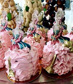 there are many cakes that look like barbies on the cake platter, and they have pink frosting