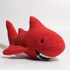 a red stuffed toy shark with its mouth open