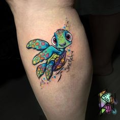 a colorful tattoo on the leg of a woman with a turtle and stars around it