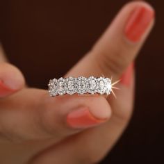 a woman's hand holding an engagement ring with three stones on it and one diamond in the middle