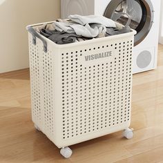 a laundry basket sitting next to a dryer on top of a hard wood floor