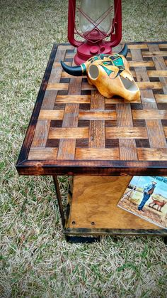 a coffee table made out of wood with a book on top and a magnifying glass next to it