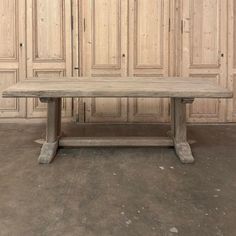 an old wooden table sitting in front of a wall