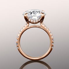 a close up view of a diamond ring on a reflective surface