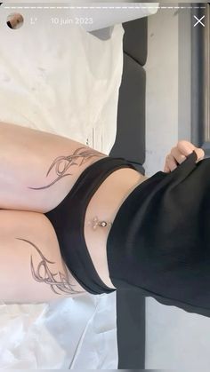 a woman with tattoos on her legs laying down