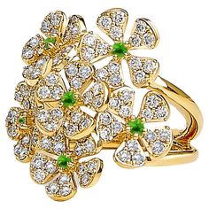 Created in 18 karat yellow gold Emeralds 0.15 carat approx. Diamonds 1.35 carats approx. Ring size US 7, can be made in other ring sizes on special order Limited edition Exquisitely crafted in 18 karat yellow gold, this limited edition ring glitters with 1.35 carats of diamonds and 0.15 carat of emeralds. Available in US 7, this ring can also be customized in other sizes upon request. About the Designers ~ Dharmesh & Namrata Drawing inspiration from little things, Dharmesh & Namrata Kothari have created an extraordinary and refreshing collection of luxurious jewels. True believers of destiny, they always feel that the possibilities of design - and life - are limitless when people work together. Formed in 2003, Syna Jewels has grown through enduring relationships with well known, establishe Luxury Yellow Gold Flower Ring With Diamonds, Flower Bunch, Green Cocktail, Spiritual Beliefs, Gold Cocktail Ring, Contemporary Ring, Gold Cocktail, Bunch Of Flowers, Gold Flower