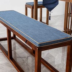 a wooden table with two chairs and a blue cloth covered bench on the bottom row