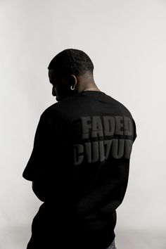 a man in a black sweatshirt with faded words on it