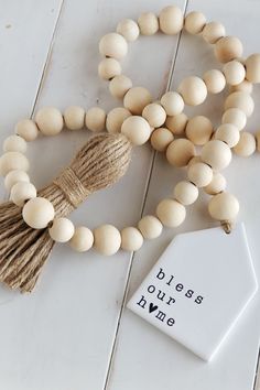 a wooden bead necklace with a tassel and tag that says, please as our own name