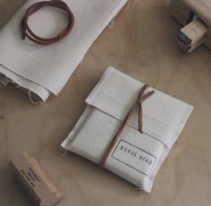 a wooden stamper and some fabric on a table with two small pieces of cloth