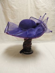 Vintage Purple Red Hat Society in Wool and Tulle with Sequins. This is a vintage Red wool hat society hat and is one size fits all. A beautiful purple floppy hat with brim turned up in the front, decorated with purple tulle, a purple sequined applique and tiny sequined at the end of each bough of tulle. The Red Hat Society is an international social organization that was founded in 1998 in the United States for women age 50 and beyond, but now open to women of all ages. Its main purpose is to pr Luxury Purple Mini Hat With Curved Brim, Cheap Adjustable Purple Hats, Purple Wide Brim Summer Costume Hat, Purple Short Brim Top Hat For Summer, Summer Wide Brim Purple Costume Hat, Summer Purple Wide Brim Costume Hat, Purple Wide Brim Top Hat For Summer, Purple Wide Brim Mini Hat For Summer, Purple Fedora Hat For Party