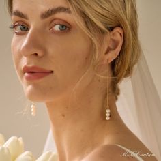 a woman in a wedding dress holding a bouquet of flowers and looking at the camera