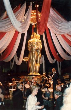 a large golden statue in front of some red and white drapes