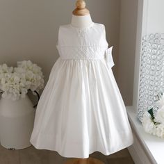 This Strasburg 100% Dupioni Silk Ivory Dress Size 24 Months Is Beautiful!! The Neckline Is Adorned With Lovely Hand-Embroidered Ivory Flowers. The Waist Has A Pin-Tucked Inlay In A Lattice Pattern With A Matching Piping Bordering The Top And Bottom. The Under Slip Has A Ruffle Of Tulle That Gives Just The Right Amount Of Volume. Upper Button Back Done In Matching Fabric Covered Buttons (A High-End Detail). A Matching Sash Ties Into A Bow In The Back For A Perfect Fit. Wonderful For Little Flower Fitted Sleeveless Cream First Communion Dress, Cream Sleeveless Fitted First Communion Dress, Classic Cream Dress For Confirmation, Classic Cream Confirmation Dress, White First Communion Dress With Pleated Bodice, White Pleated Bodice Dress For First Communion, White Classic Dress For First Communion, Ivory Dress, Dupioni Silk