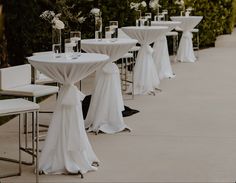 tables and chairs with white tablecloths are lined up