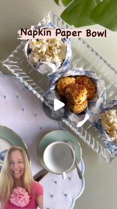 a table topped with plates and cups filled with food next to a bowl of popcorn