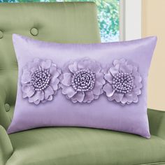 a purple pillow with three flowers on it