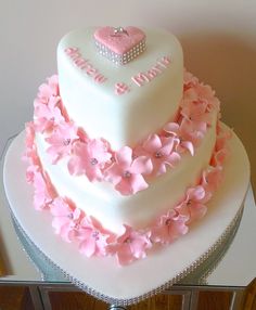 a heart shaped cake decorated with pink flowers