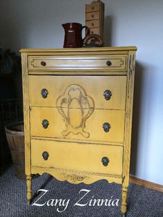 an old dresser painted yellow with black knobs