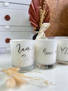 three candles are sitting on a white table