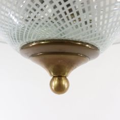 a close up of a light fixture on a white wall with a mesh covering over it