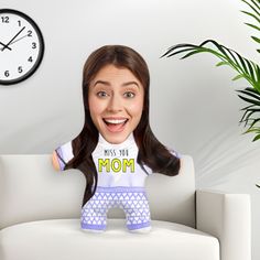 a woman sitting on top of a white couch next to a clock and potted plant