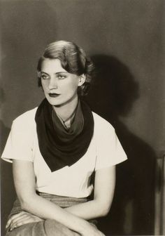 an old black and white photo of a woman sitting on the floor wearing a scarf